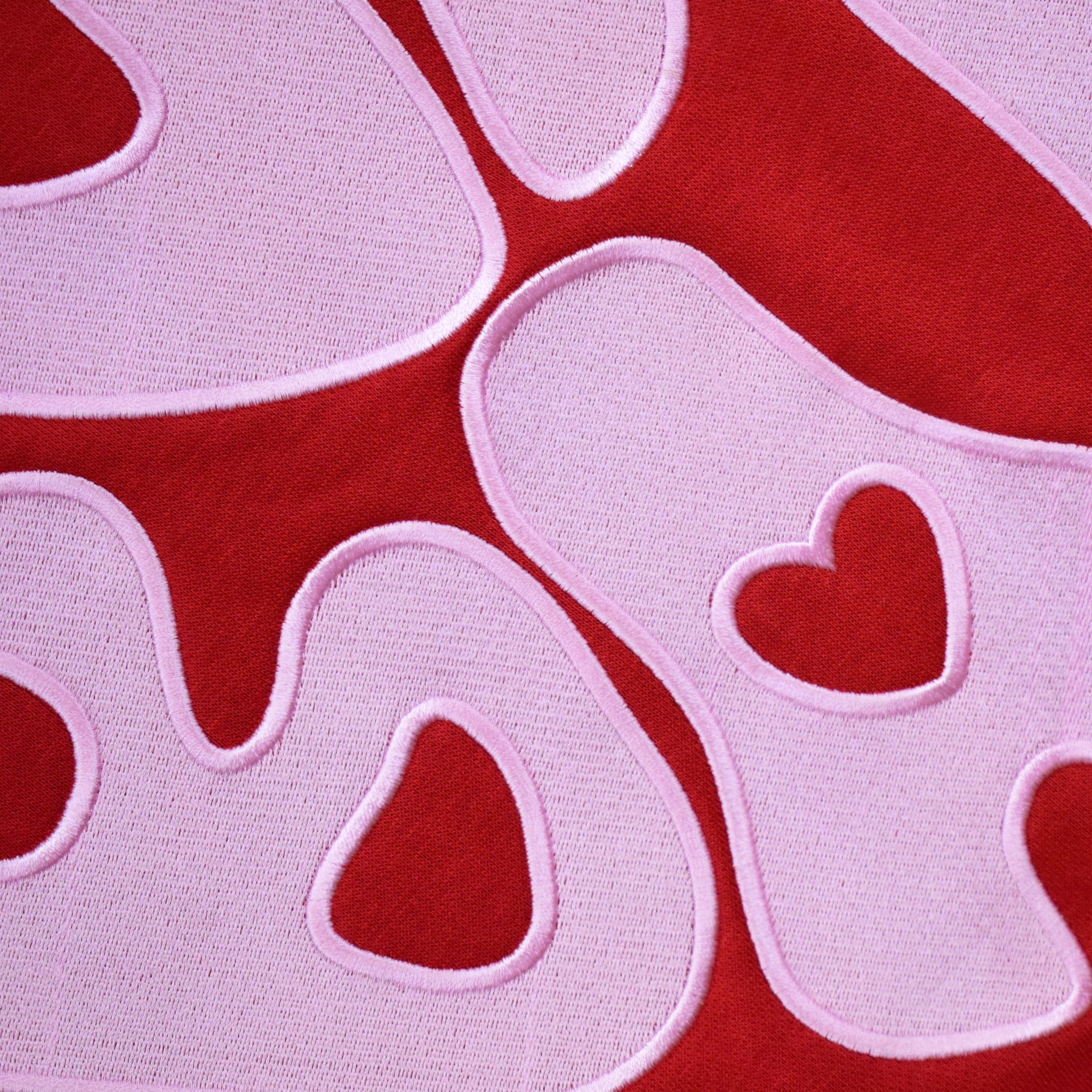 Close-up of pink SUNBAE embroidery on Red Hoodie