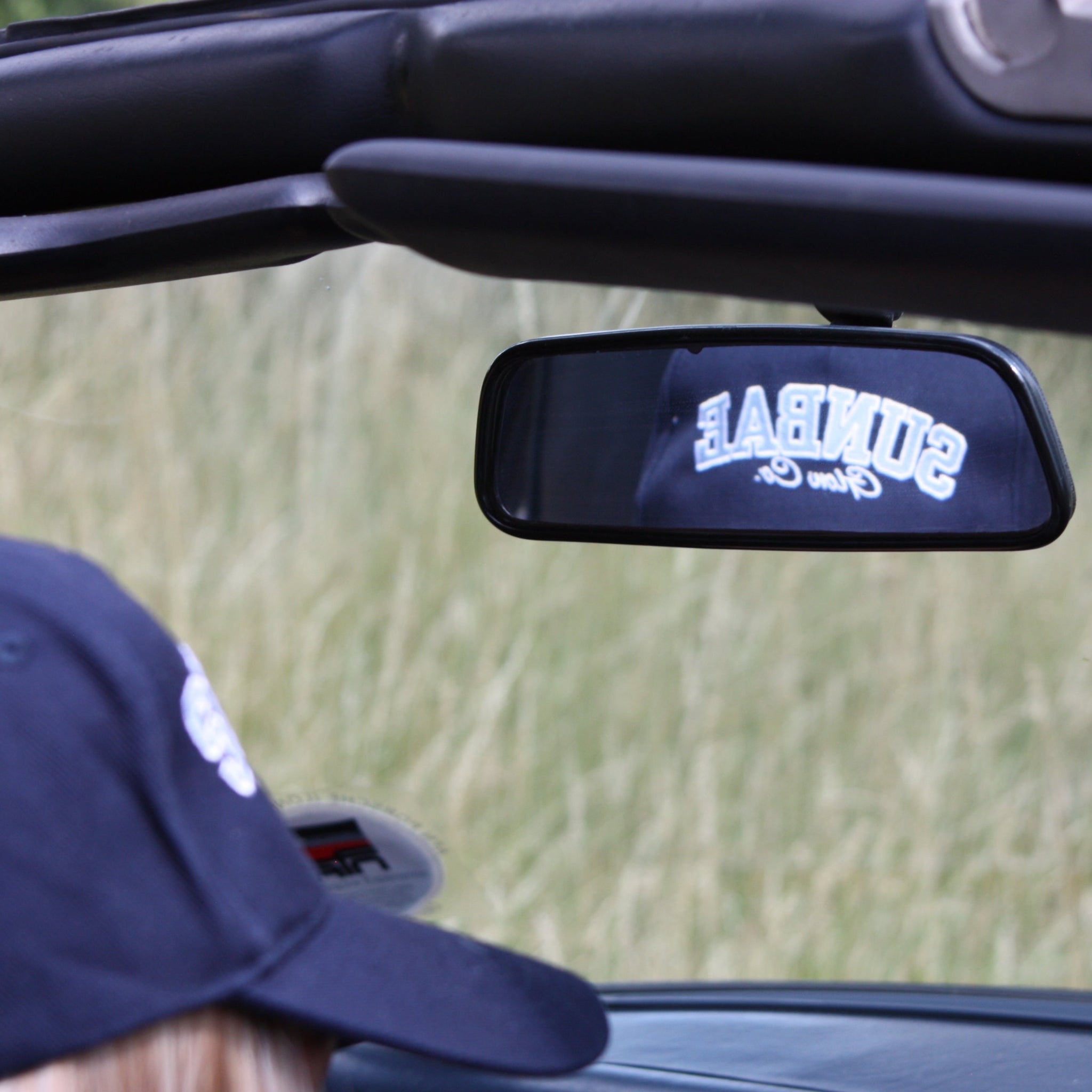 Sunbae Solar Cap reflected in car rear view mirror