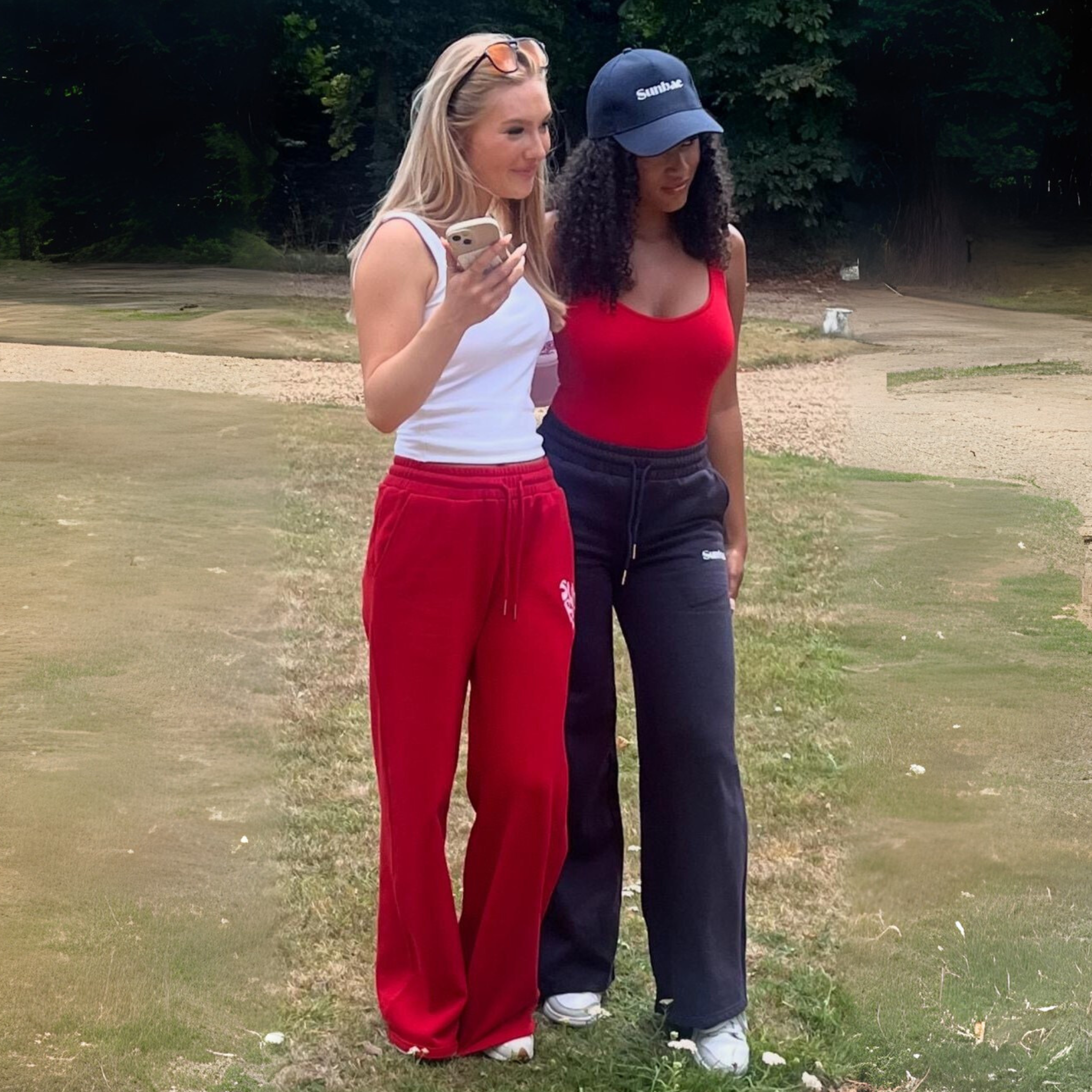 Two women standing outdoors on a grassy area, wearing SUNBAE Sweat Pants