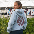 Yvonne Main wearing a hoodie with 'Sunbae' text in front of a stadium.
