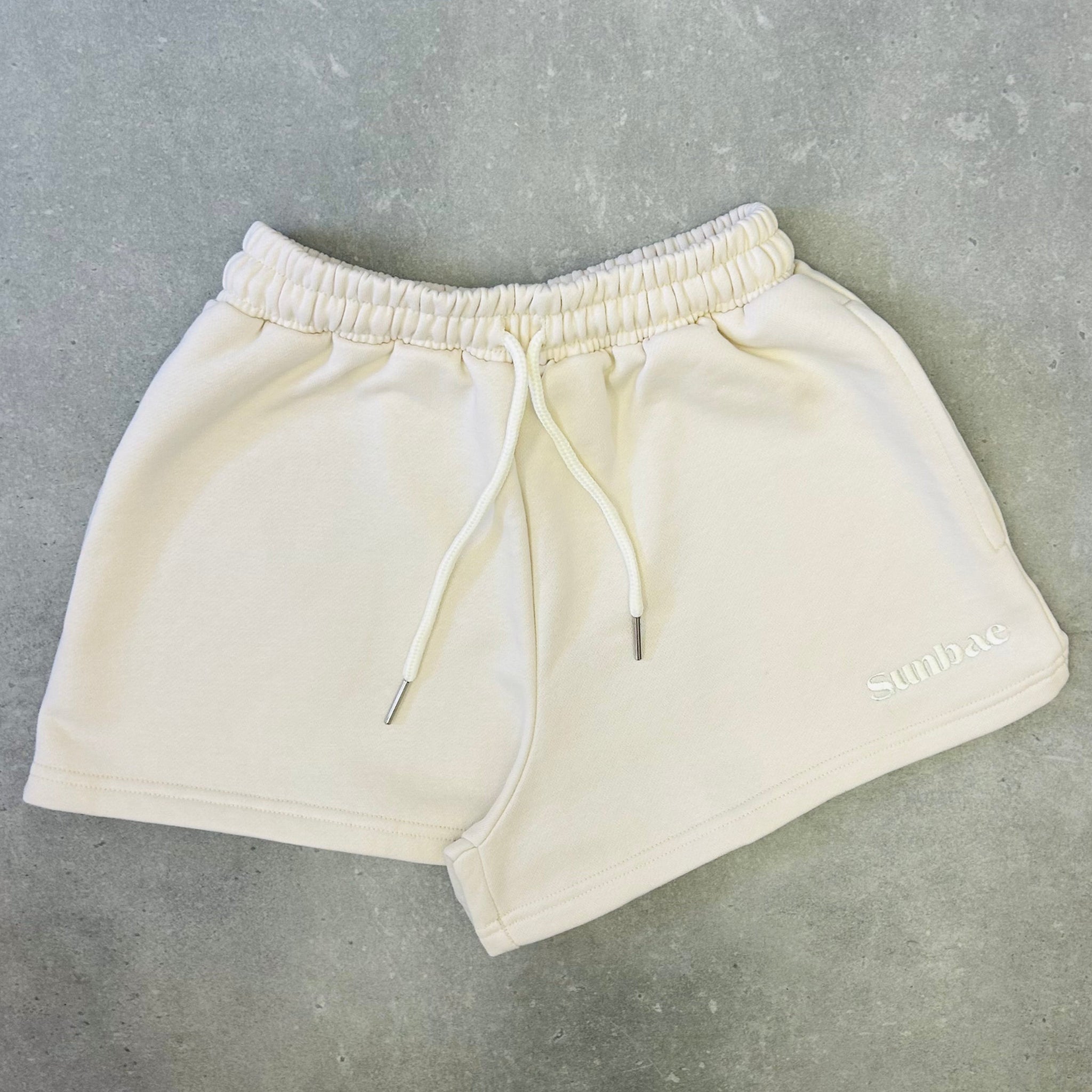 Beige shorts on a gray concrete floor