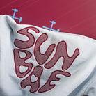 Close-up of a Sunbae Hoodiw with branding on a red background