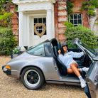 Sunbae Glower wearing  SUNBAE Cloudburst Zip Sweat with Jetset Embroidery in White sitting in a silver Porsche car 