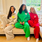 Sunbae Glow Collective sitting on a couch wearing Sunbae Glazed Heart Hoodies and Sunbae Glazed Heart Sweat Pant