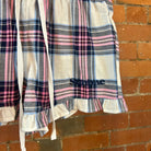 Plaid SUNBAE short with ruffles hanging on a brick wall