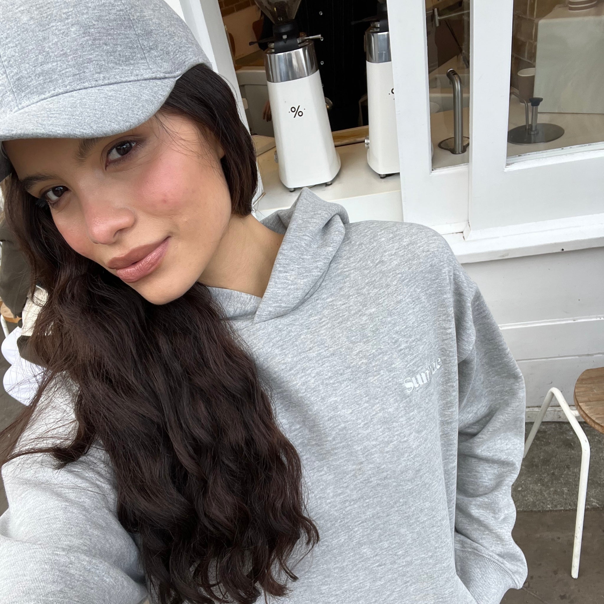 Person wearing a gray hoodie in an indoor setting