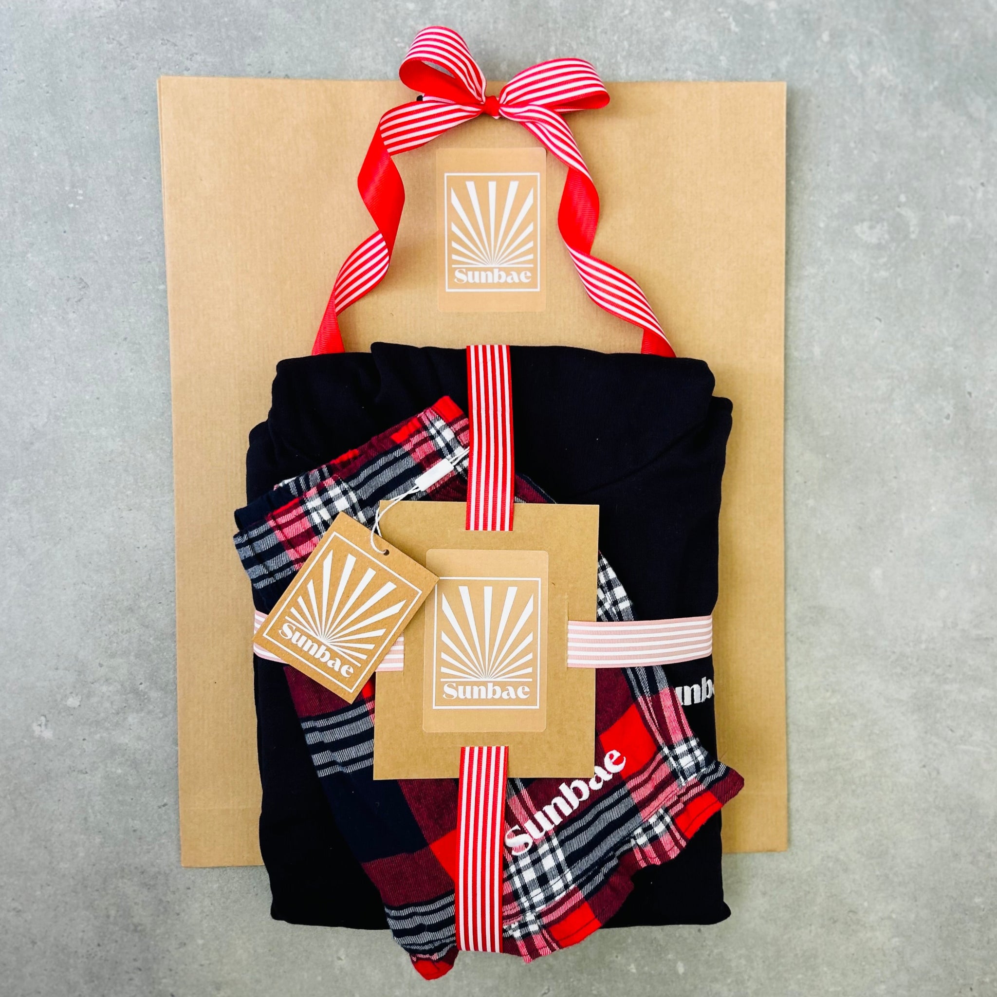 Set of plaid socks in a gift box with a ribbon on a gray background