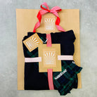 Packaged SUNBAE Shorts and Hoodie with a red ribbon on a gray surface