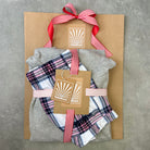Packaged gift set with plaid fabric and gray cloth on a textured surface