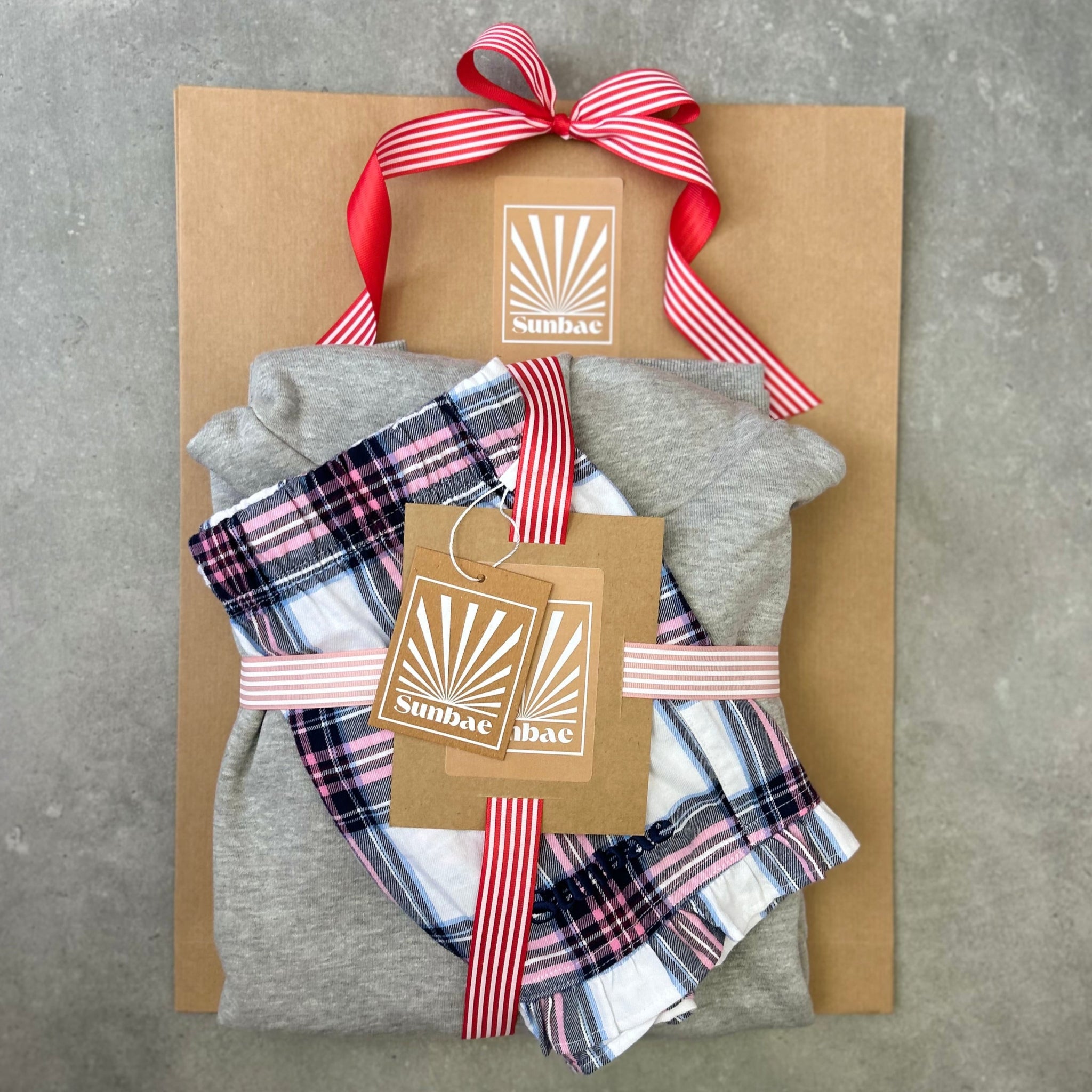 Packaged gift set with plaid fabric and gray cloth on a textured surface