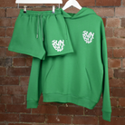 Green Shorts and Hoodie on hangers with SUNBAE logo embroidered in white on a brick background