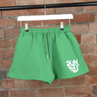 Green Shorts with SUNBAE logo embroidered in white on a brick background