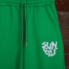 Green Sweat Pant with SUNBAE logo embroidered in white on a brick background